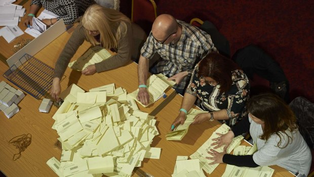 Counting staff sort ballot papers at a vote-counting centre in Margate, southeast England during the British general election. 