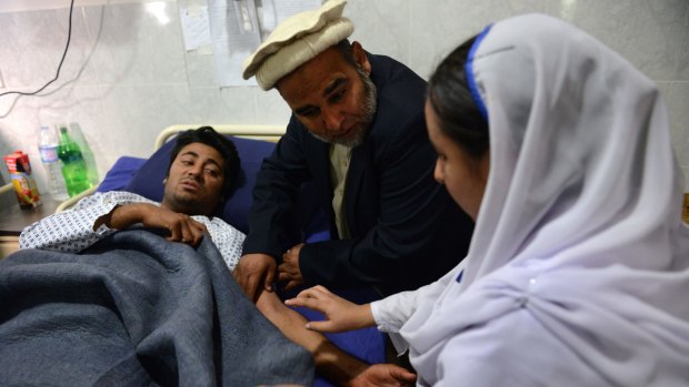 A Pakistani health worker treats an injured student at a hospital a day after an attack by Taliban militants at an army-run school in Peshawar.