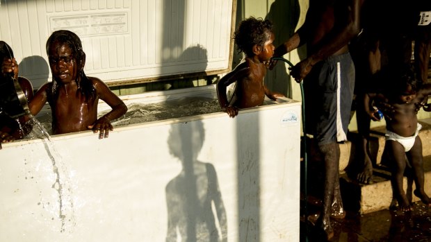 Children play in a fridge in Perederr after fleeing the violence-struck community of Wadeye, Northern Territory.