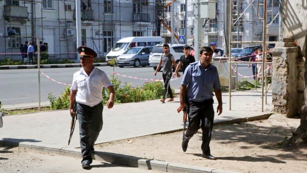 Police officers secure an area in the capital of Tajikistan, Dushanbe, where several Interior Ministry special forces officers and a traffic policeman were reportedly shot dead.