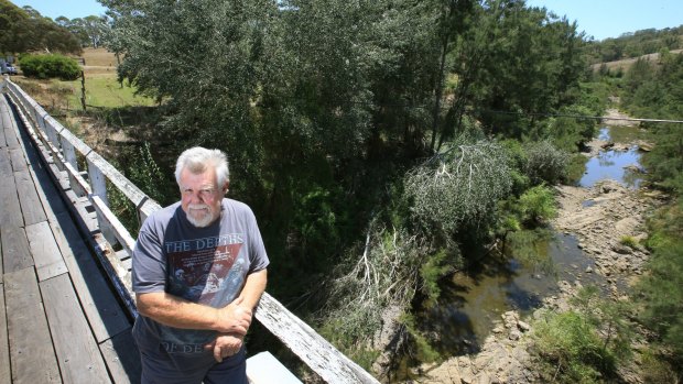 Stark contrast: Torryburn Stud owner John Cornish standing on a bridge over the Allyn River in February 2014. The river had stopped flowing and was too low to be used to pump water.