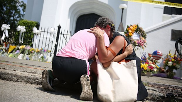  Women comfort each other as they mourn in front of the Emanuel African Methodist Episcopal Church after a mass shooting at the church that killed nine people in Charleston, South Carolina.