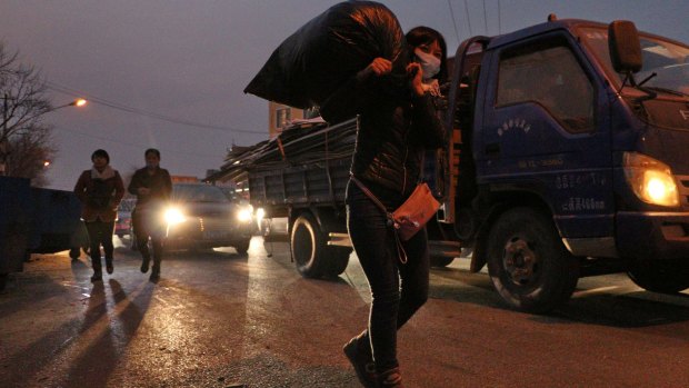 Zhou Xiaomei, 44, a house cleaner in Beijing, moves her belongings.