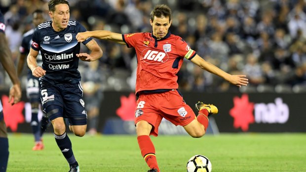 Drought over: Isaias Sanchez strikes past Victory's Mark Milligan, as Adelaide claim their first win at Etihad Stadium since 2006.