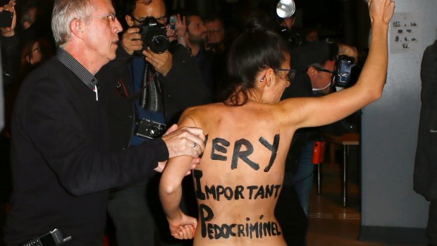 A Femen activist is led away by security staff at the film institute La Cinematheque Francaise.