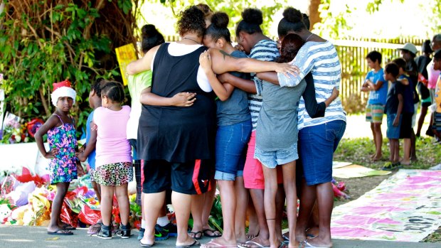 Mourners gather outside the Cairns house where eight children were murdered.