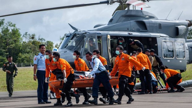 Search and rescue workers carry the body of a victim of the AirAsia flight in Pangkalanbun.