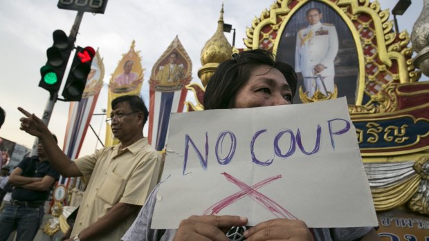 Protesters next to portraits honouring Thai King Bhumibol Adulyadej during anti-coup demonstrations in Bangkok in May last year. 