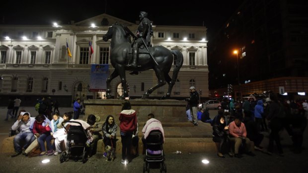 Residents sit in Santiago's main square after a powerful earthquake hit Chile's northern coast causing buildings to sway in the capital.