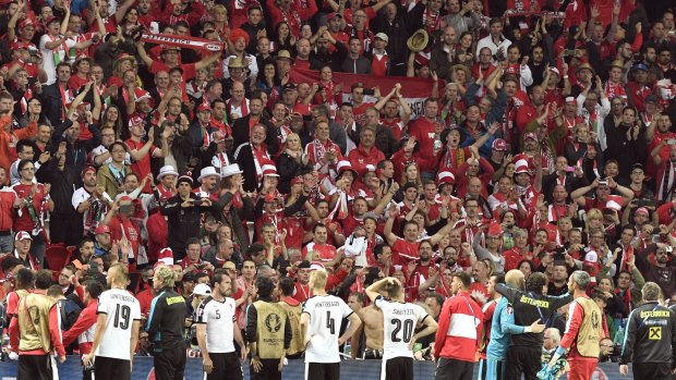 Overachievers: Austria players celebrate with supporters after their surprise 0-0 draw with Portugal.