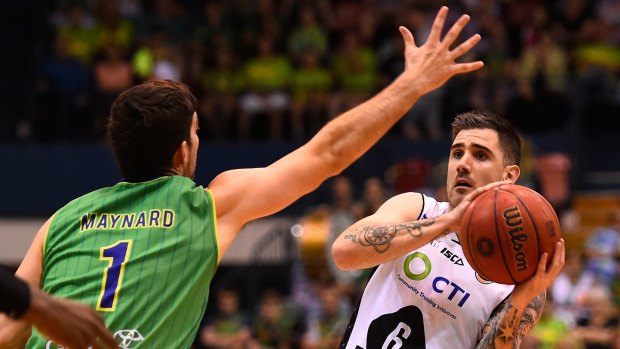Nate Tomlinson of Melbourne United looks to pass the ball past Corey Maynard of Townsville.