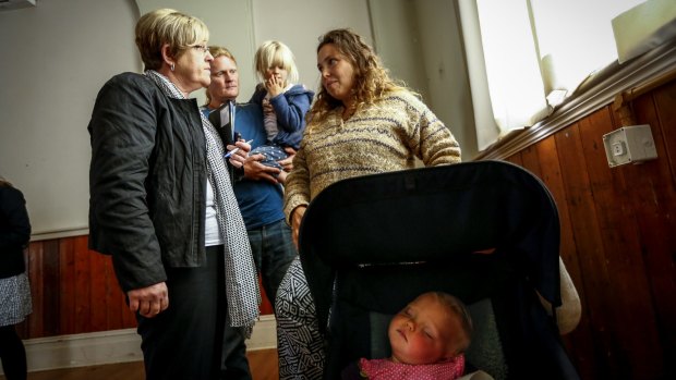 Environment Minister Lisa Neville speaks with Martin Fitzsimons and wife Ynte Kylstra, pictured with their children Stella and Erica, at a community meeting in Lancefield on Monday.
