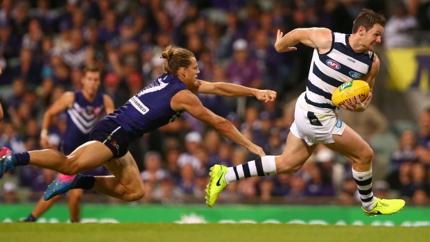 Patrick Dangerfield breaks clear of a tackle from Nathan Fyfe.