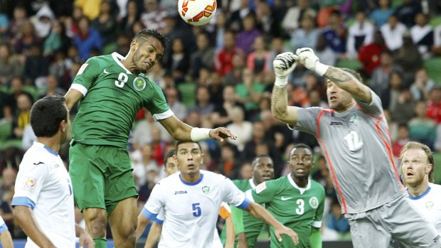 Valiant attempt: Saudi Arabia's Naif Hazazi head for goal against Uzbekistan's goalkeeper Ignatiy Nesterov.
