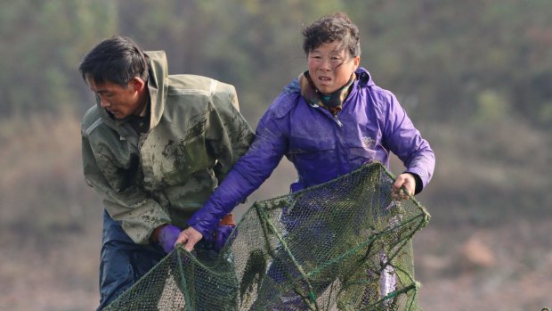 Two North Korean fishermen working on the Yalu River.