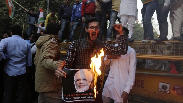 A member of the Indian Youth Congress shouts slogans as he burns a portrait of Indian Prime Minister Narendra Modi in Delhi, India, on Friday to protest against Mr Modi's visit to Pakistan.