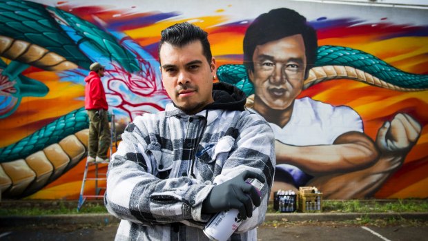 David 'Dsee' Chavez and with the mural of Jackie Chan on Challis Street in Dickson. 