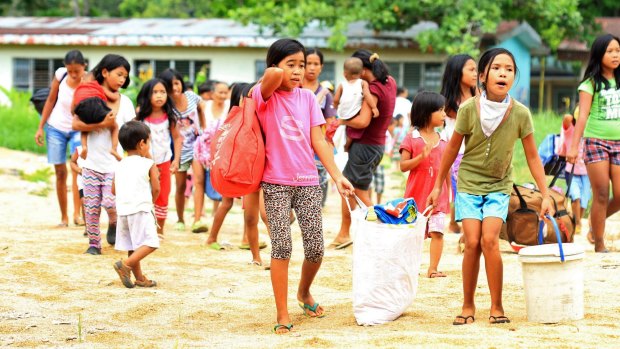 Residents carry their belongings away from the volcano.