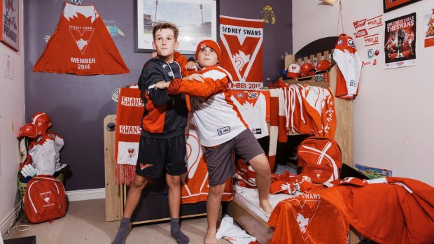 Brothers Ryan (left) and Jude O’Keefe show off the red and white colours of their team, the Sydney Swans.