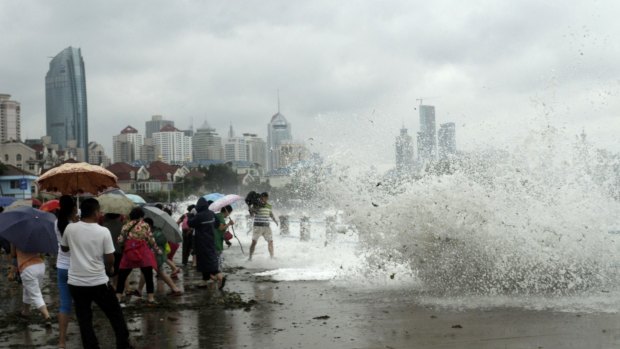 People run away from massive waves as Chan-hom hit the seacoast of Qingdao in east China's Shandong province on Sunday.