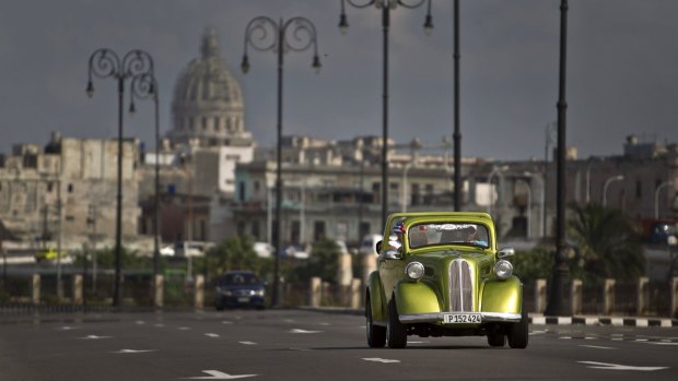 A man drives a classic American car on The Malecon in Havana. The cars have become an icon of tourism in the socialist nation.