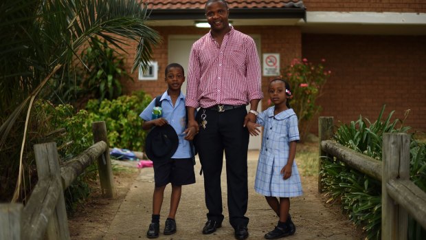 Lamin Tucker with two of his children, Francis  and Giselle, at their home in Marrickville, Sydney. 