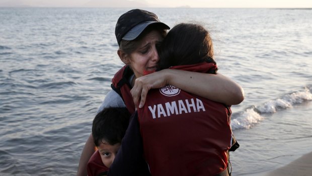 A woman hugs her children after making it to the Greek island of Kos.