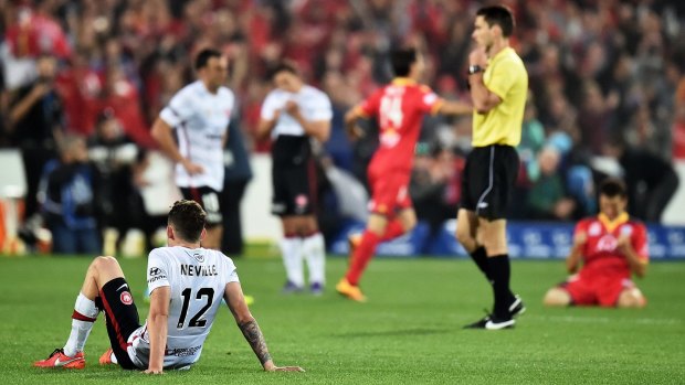 Unhappy Wanderer: Scott Neville sits dejected after the the Wanderers' 3-1 defeat to Adelaide United.