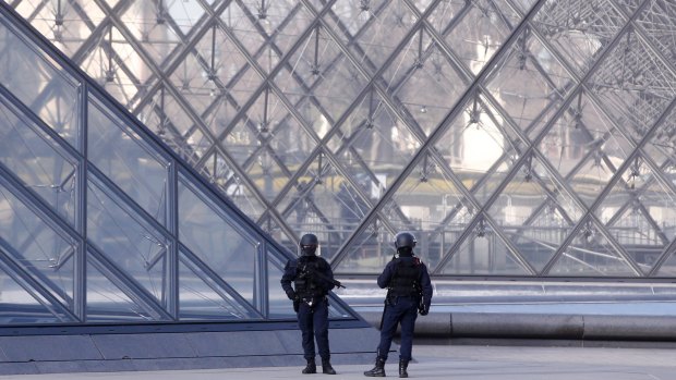 Police officers patrol at the pyramid outside the Louvre in Paris.