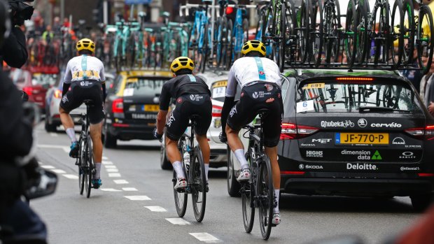 Britain's Chris Froome, his pants torn after crashing, follows teammates to catch up with the peloton.