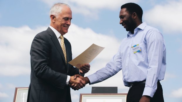 Prime Minister Malcolm Turnbull welcomes a new citizen at an Australia Day ceremony.