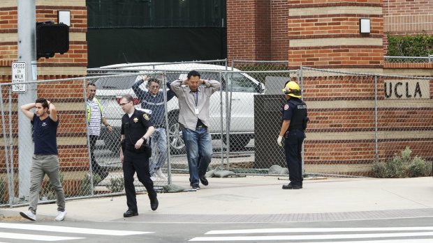 People are escorted by emergency personnel away from the scene of a fatal shooting at the University of California, Los Angeles.