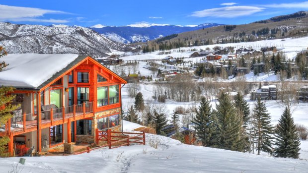 Snowmass - a ski resort with a background of a small residential area (small huts) surrounded by trees.