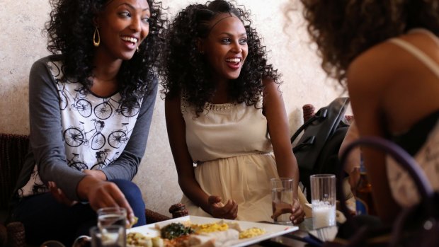 Lunch-goers share a 'yetsom beyaynetu' mixed plate of vegan Ethiopian food at a restaurant in the capital, Addis Ababa. 