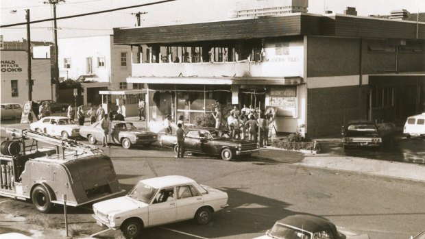 Onlookers mill around the burned out Whiskey Au Go Go night club, Brisbane, in which 15 people died.