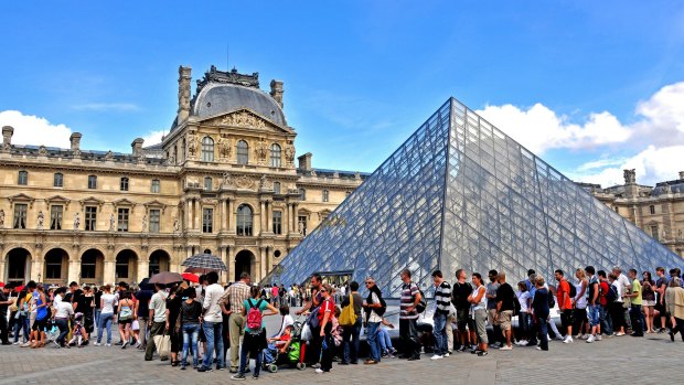 Tourists queue before the Pyramid of Louvre museum, Paris, France.