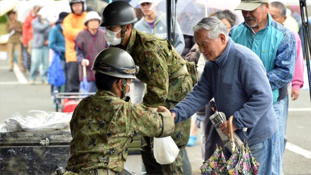 A resident receives rations in Mashiki, Kumamoto prefecture on Monday. 