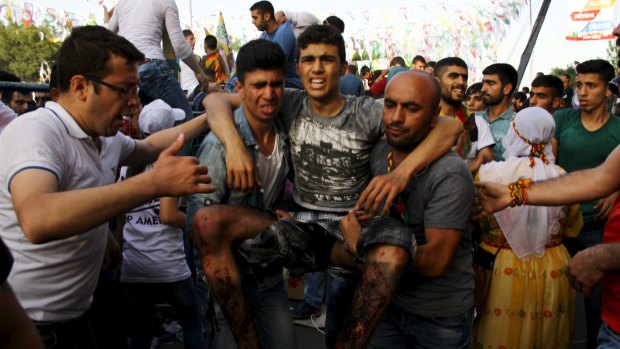An injured man is carried away after the  explosion at an election rally in Diyarbakir.