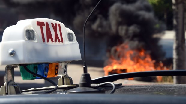 French taxi drivers burn tyres during a protest against Uber in Marseilles.