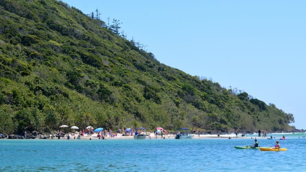 Visitors relax on the beach in Tallebudgera Creek.