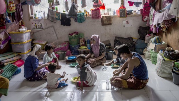 Rohingya refugee Sajidah Begum, 25, left, eats with her children at a temporary shelter in Bayeun.