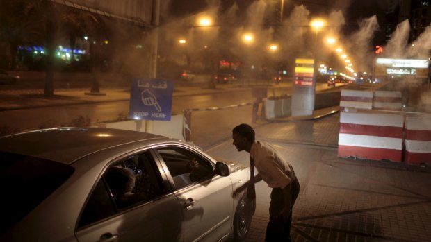 A cars stops at a checkpoint near the entrance of a mall, just after midnight in Riyadh.