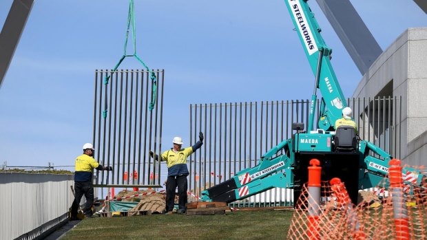 A security fence is installed across the lawns of Parliament House in Canberra.