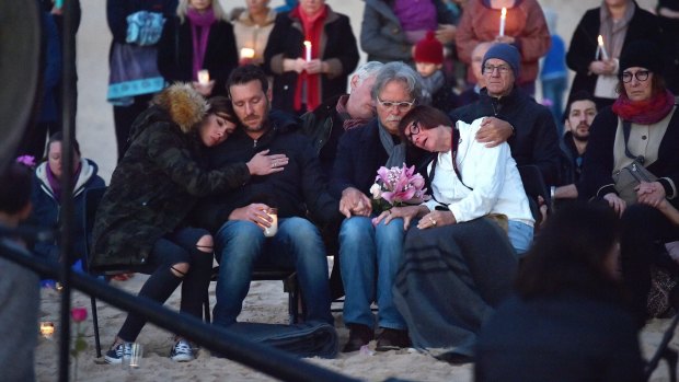 Justine's parents Maryan Heffernan, and John Ruszczyk, right, with their son Jason Ruszczyk and his wife Katarina Ruszczyk, left at Freshwater Beach during a vigil for their daughter. 