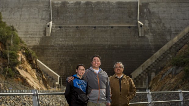 Three generations of the Hansen family Joe, 12, Richard and David watch the first spill of the Cotter Dam.