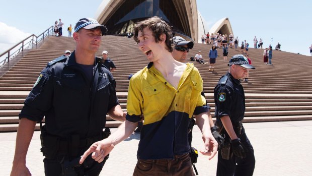 An activist who was involved in an attempt to unfurl a protest banner over a sail of the Sydney Opera House is arrested.