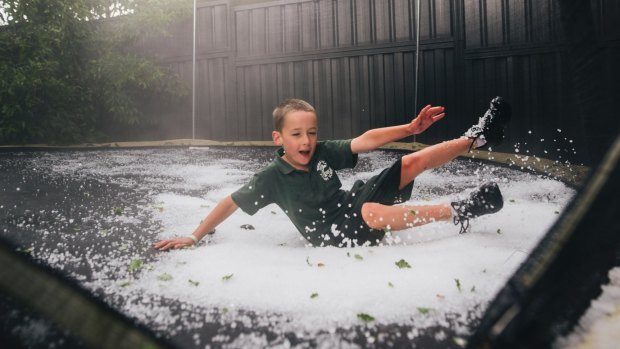 Campbell Ashcroft, 6, of Yarralumla, playing in the hail on his backyard trampoline.