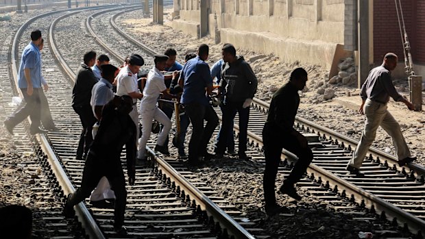 Egyptian security forces and rescue workers carry an injured person to safety.