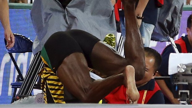 Over it: Usain Bolt of Jamaica collides with a cameraman on a Segway after the men's 200m final.