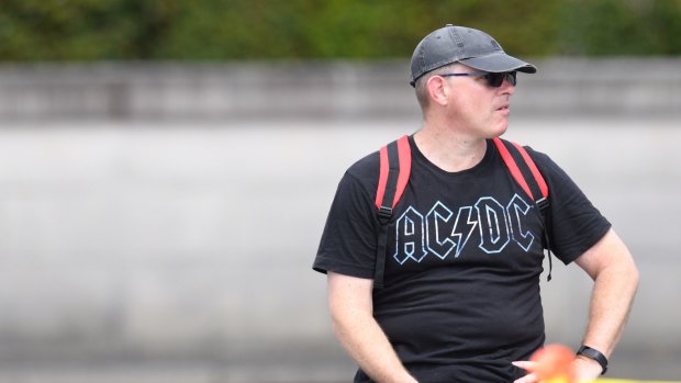 An AC/DC fan sits outside the funeral.